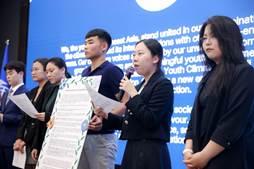 A group of people standing in front of a blue wall
AI-generated content may be incorrect.