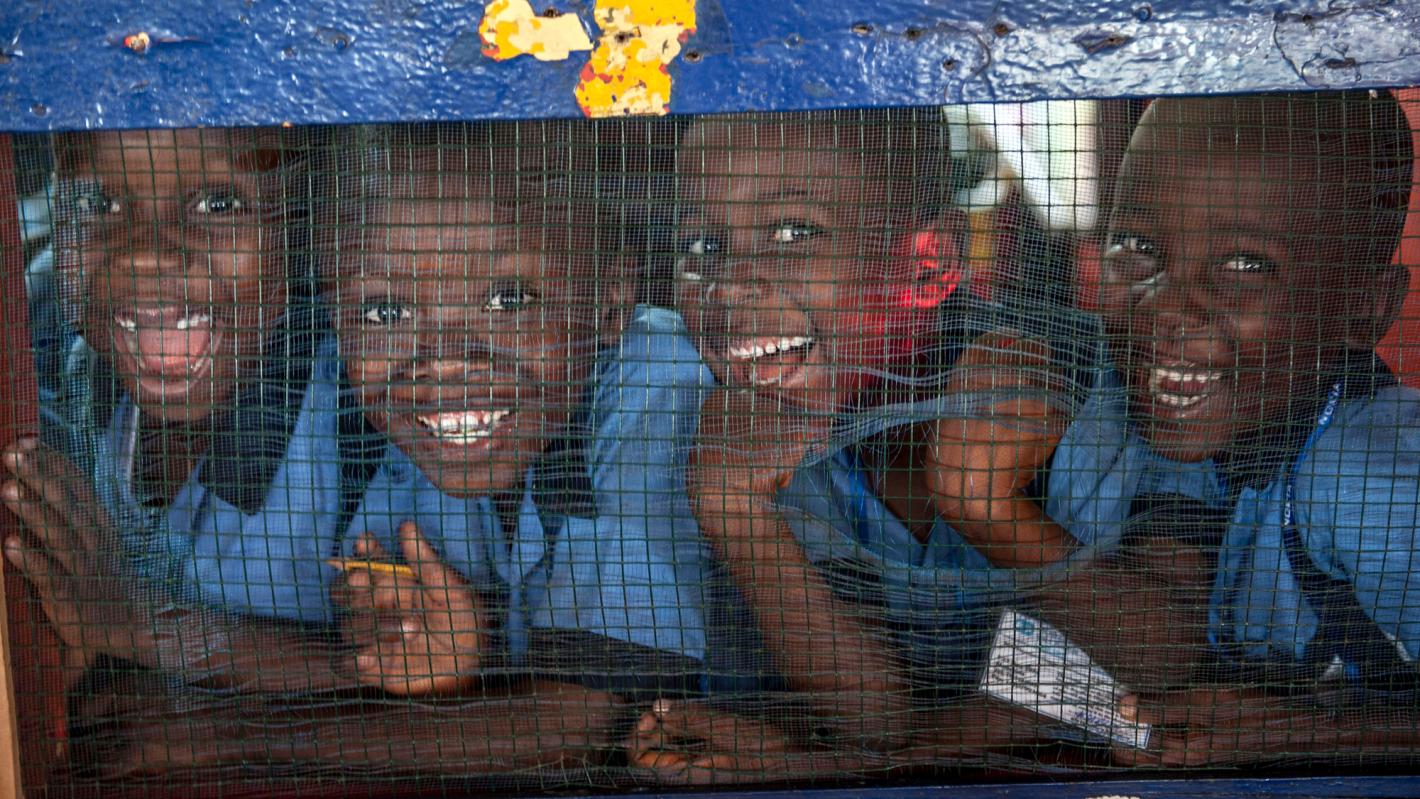 Students of the Herman Gmeiner School in SOS Children’s Village, Monrovia, smile for the camera during an outreach event by the UN Mission in Liberia (UNMIL) on today’s annual UN Day. UN Photo/Staton Winter Four children in a row smiling