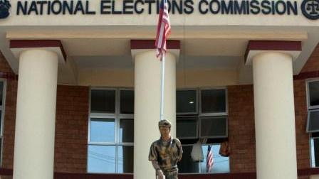 A peacekeeper raising a flag outside the Liberian National Elections Commission