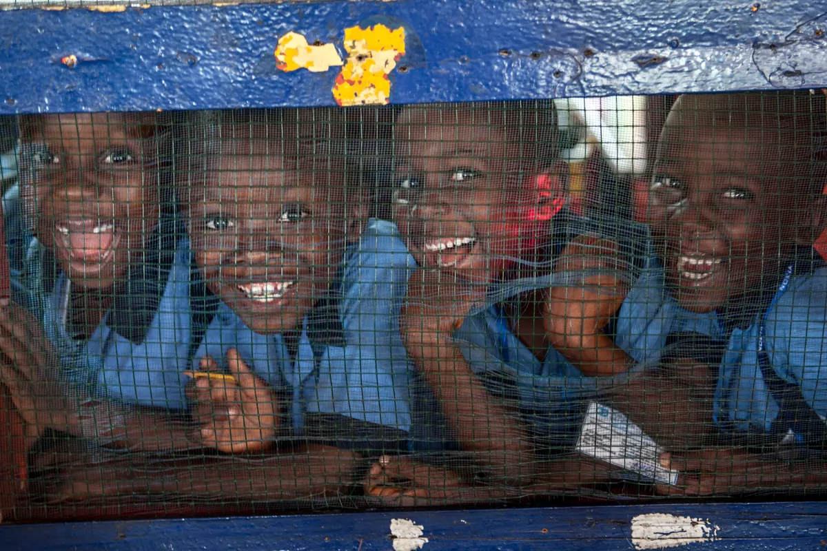 Students of the Herman Gmeiner School in SOS Children’s Village, Monrovia, smile for the camera during an outreach event by the UN Mission in Liberia (UNMIL) on today’s annual UN Day. UN Photo/Staton Winter Four children in a row smiling