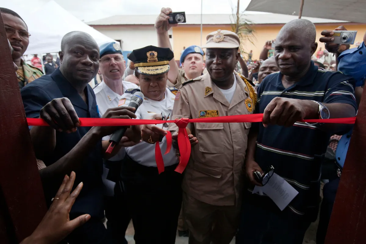 Deputy Commissioner of the Liberian National Police, cuts the ribbon on a new security depot in Margibi County. UN Photo/Staton Winter Police officers cut a red ribbon to open the new security depot.