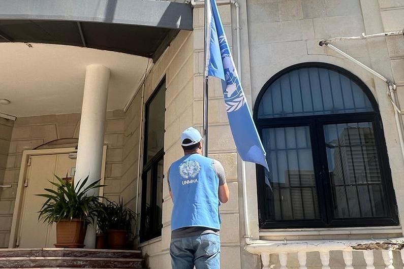 The United Nations flag is lowered at a UN building in Yemen. A UN staff is is lowering the UN flag at a UN building in Yemen