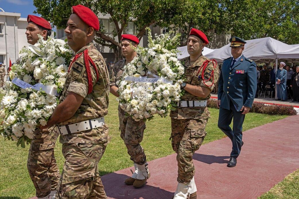 Peacekeepers carry flowers.